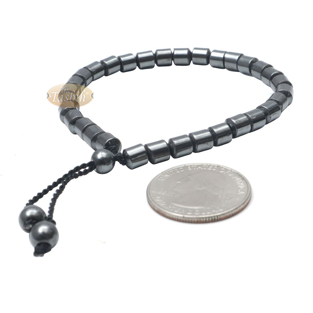 Black cylindrical-bead Islamic tasbih bracelet with adjustable cord.
